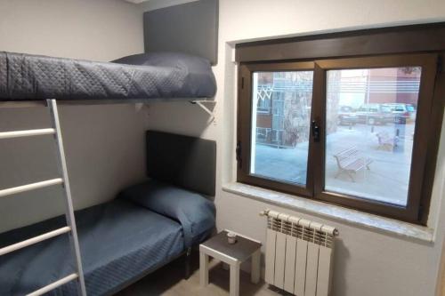 a small room with a bunk bed and a window at apartamento a 19min de Gijón y 15 de Oviedo in Langreo