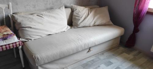 Sofá blanco con almohadas en una habitación en Maison au pied de la montagne, en Aspet