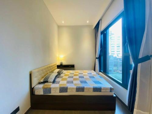 - une chambre avec un lit et une grande fenêtre dans l'établissement The Rixx Iconic Apartment @ D1/pool/gym/Netflix, à Hô-Chi-Minh-Ville