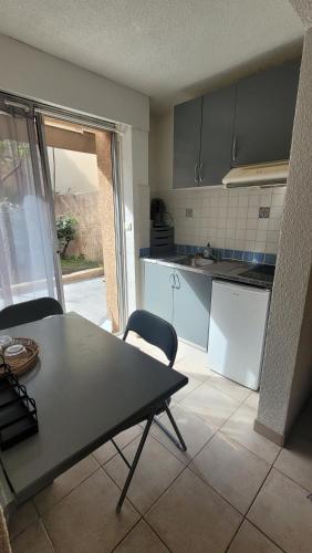 une cuisine avec une table et des chaises dans une pièce dans l'établissement Studio situé à 20 metres de la plage d Agosta Porticcio, à Albitreccia