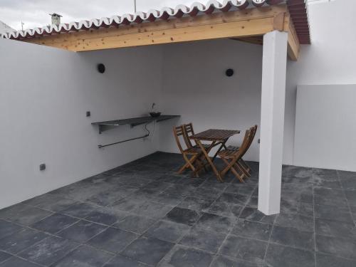 a patio with a table and chairs in a room at A Casinha in Angra do Heroísmo