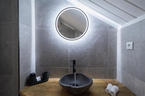 a bathroom with a stone sink and a mirror at Hôtel Maison Doron in Beaufort