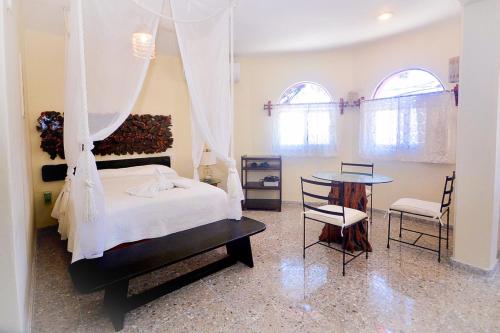a bedroom with a bed and a table and chairs at Hotel Delfin in Playa del Carmen