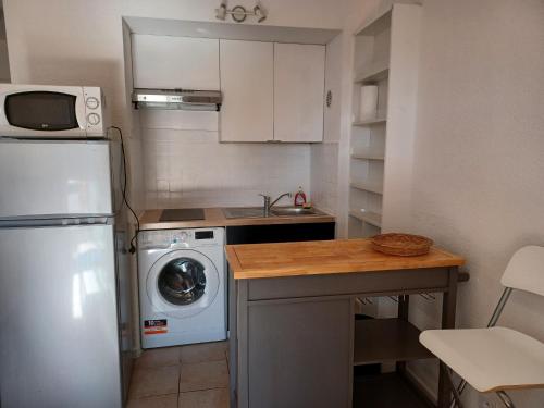 een kleine keuken met een koelkast en een wasmachine bij STUDIO PORT 200 M PLAGE in Canet-en-Roussillon