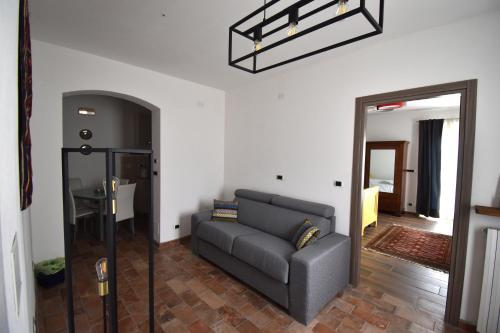 a living room with a couch and a mirror at Cascina Tre Botti in Agliano Terme
