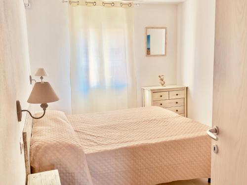 イーゾラ・ロッサにあるL'Approdo Apartmentsの白いベッドルーム(ベッド1台、ドレッサー付)