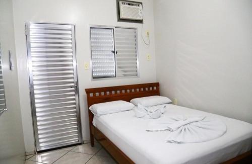 a small bedroom with a bed and a window at SWAMY HOTEL ANEXO I in Cruzeiro do Sul