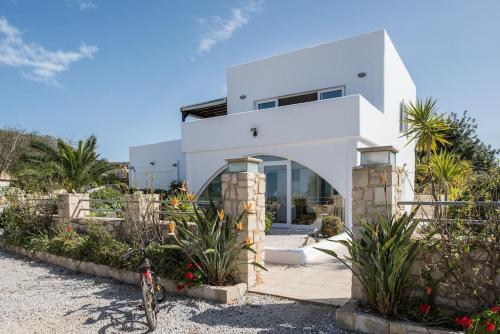 a white house on the beach with a bike in front at Wonderful Villa Melodie in Plaka