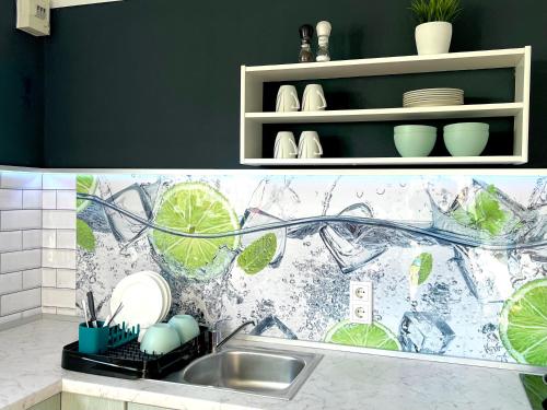 cocina con fregadero y pared verde en FeWo Sunshine en Heringsdorf