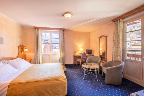 una camera d'albergo con letto e scrivania di Hotel Relais Orsingher a Fiera di Primiero