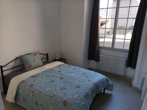um quarto com uma cama com uma colcha azul e uma janela em O'Couvent - Appartement 87m2 - 4 chambres - A511 em Salins-les-Bains