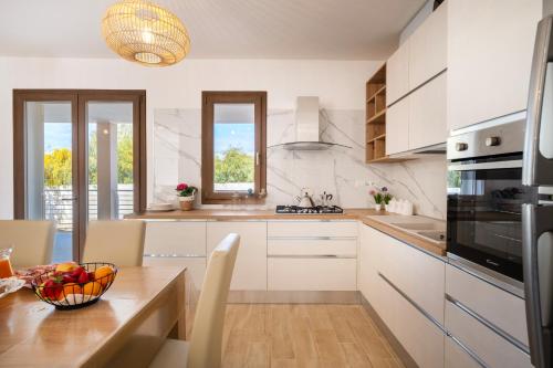 a kitchen with a table with a bowl of fruit on it at Villa Solymar in Alghero