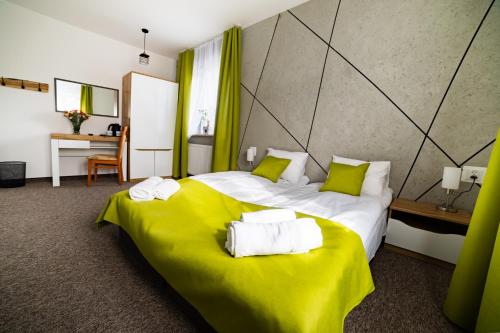 une chambre d'hôtel avec un grand lit et des serviettes. dans l'établissement Rezydencja Klonowa, à Ober Wüstegiersdorf