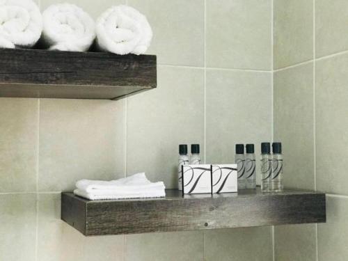 een plank in een badkamer met handdoeken bij Lekuka Guesthouse in Lobatse