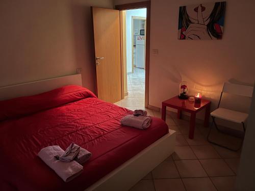 een slaapkamer met een rood bed en handdoeken erop bij Villetta Audrey al Mare in Riccione