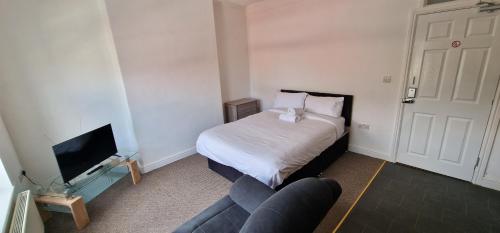 a bedroom with a bed and a couch and a tv at SELF CHECK IN APARTMENT DONCASTER in Doncaster