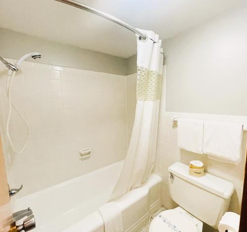 een badkamer met een wit bad en een toilet bij The Madison Inn Motel in Fort Madison