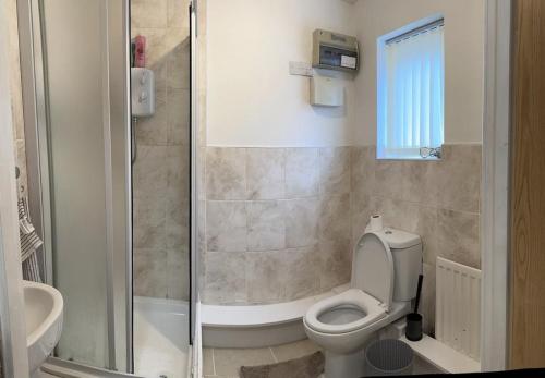 a bathroom with a toilet and a shower at Rooms 7 minutes from Etihad in Manchester