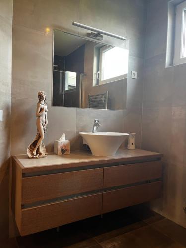 uma casa de banho com um lavatório e uma estátua de uma mulher em Guest house TOMAN em Bled
