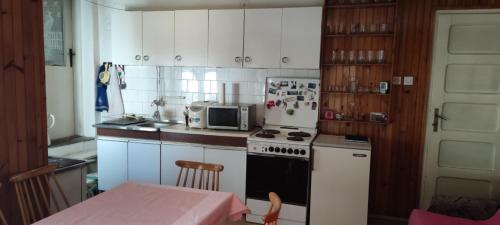 eine Küche mit einem Herd, einer Mikrowelle und einem Tisch in der Unterkunft Villa Ljubica 