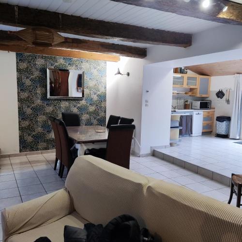 a living room with a table and chairs and a kitchen at Gîte de l'Escapade in Frossay