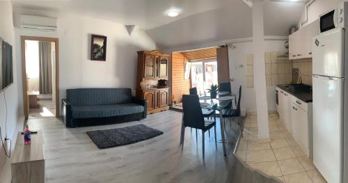 cocina y sala de estar con mesa y sofá en Apartament în regim hotelier en Timisoara