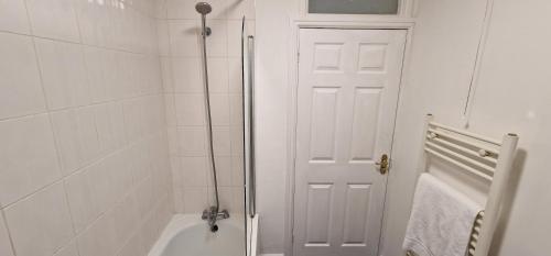 a white bathroom with a shower and a white door at SELF CHECK IN APARTMENT DONCASTER in Doncaster