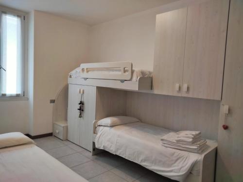 une petite chambre d'hôpital avec un lit et une armoire dans l'établissement APPARTAMENTO PERSEO, à Lezzeno