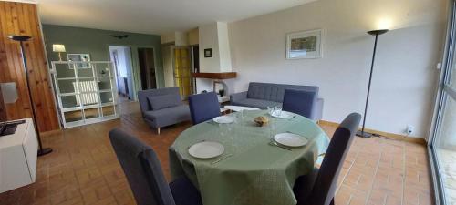 une salle à manger avec une table et des chaises vertes dans l'établissement Terrasse, jardin,, Appartement 80m², vue montagne, wifi, bureau, à Bagnères-de-Bigorre