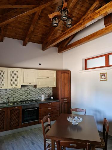 cocina con mesa de madera y techo de madera en Affittacamere Le Querce, en Teggiano