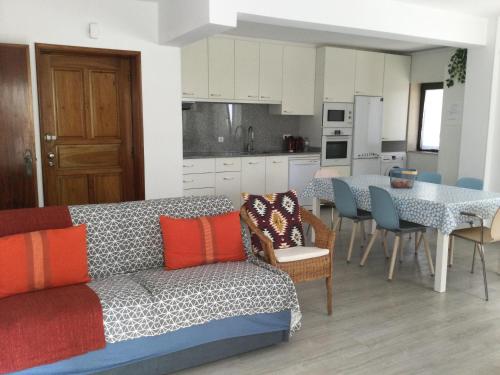a living room with a couch and a table with chairs at Estrela de Aver o Mar in Póvoa de Varzim