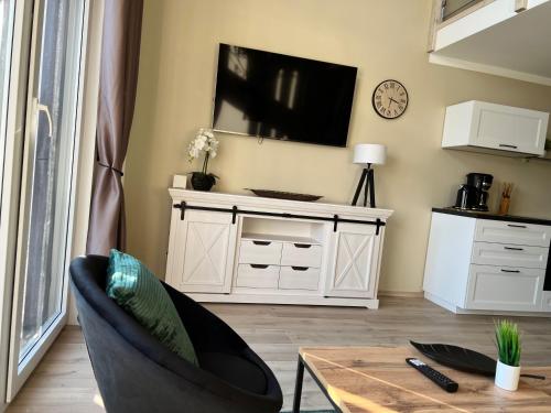 a living room with a tv on a wall at Casa Kashubia - Nowoczesny dom wakacyjny nad jeziorem - Cisza natura i komfort in Brzeźno Szlacheckie