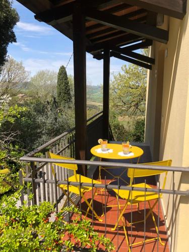 einen Tisch und Stühle auf einem Balkon mit Aussicht in der Unterkunft Didi House in Montepulciano