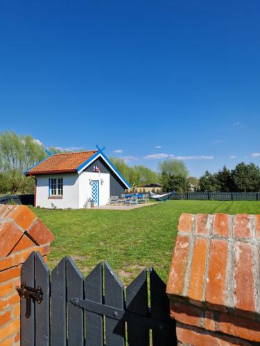 a house with a gate in front of a yard at Pieninė in Ventė