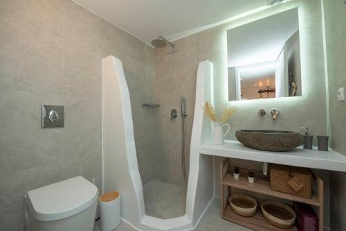 uma casa de banho com um chuveiro, um WC e um lavatório. em Casa Piccolino em Míconos