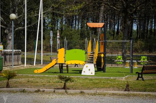 a playground with a slide in a park at Villas du lac in Soustons