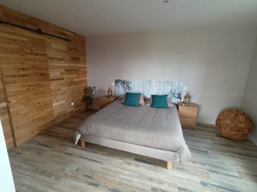 1 dormitorio con 1 cama grande con almohadas azules en Un Brain de nature en La Chapelle-de-Brain