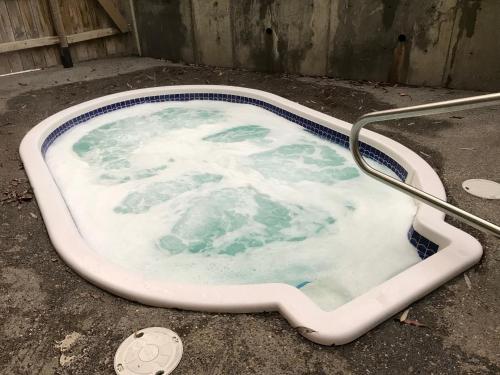 a bath tub filled with water in a dirty room at Silver Rock Condominiums by Fernie Central Reservations in Fernie