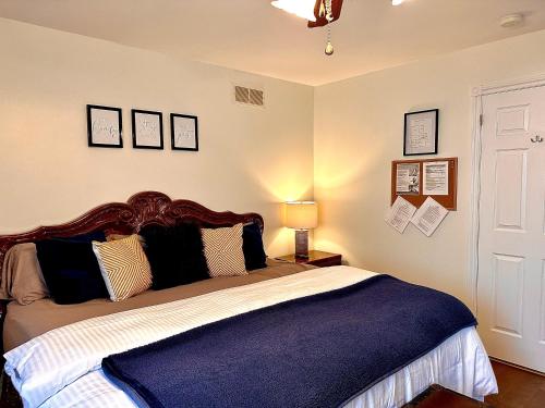 1 dormitorio con 1 cama grande con manta azul en Settlers Suites en Niagara on the Lake