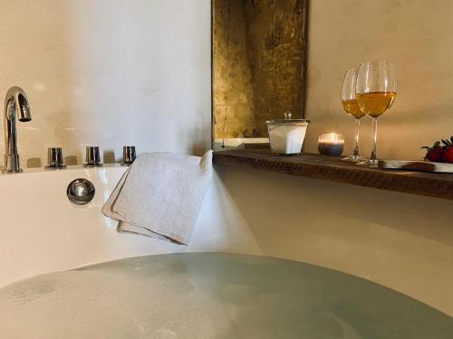 a bath tub with a glass of wine and a towel at Capannacce Organic and Horse Farm in Rapolano Terme