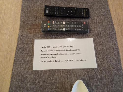 two remote controls sitting on a table with a receipt at Celý rodinný dům na venkově in Kouřim