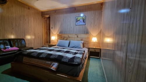 ein Schlafzimmer mit einem Bett, einem Stuhl und zwei Lampen in der Unterkunft Sehrish Guest House Skardu in Skardu