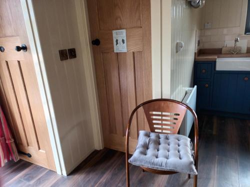 a chair in front of a kitchen with a door at Rathgillen Cabin in Nobber