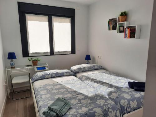 two twin beds in a room with a window at Apartamento Dindurra Centro Playa in Gijón