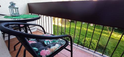 uma cadeira sentada numa varanda ao lado de uma mesa em Apartament boBoski em Wadowice