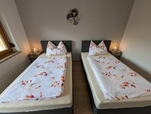 two beds in a small room with two lamps at Angerpartments-Sonnige große Wohnung mit Balkon und kostenlosen Parkplatz in Döbriach