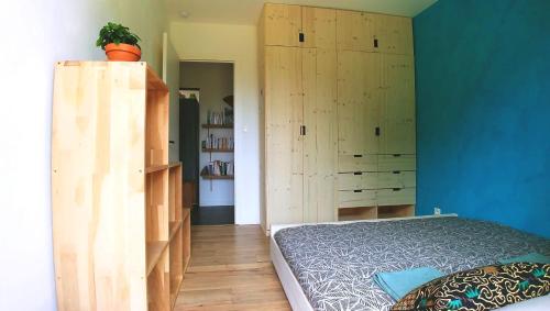 a bedroom with blue walls and a bed and wooden cabinets at Seignosse : Mandago Surf Home in Seignosse