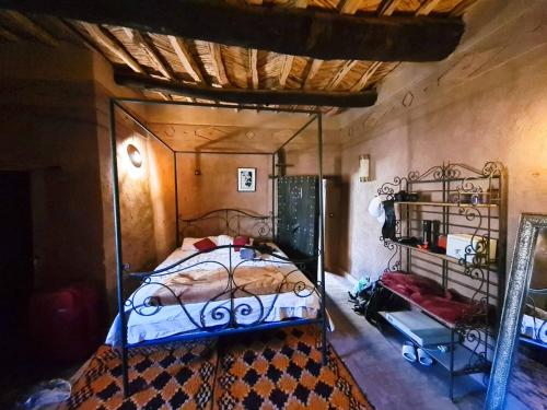 a bedroom with a bed with a wrought iron frame at Kasbah des montagnes maison d'h&ocirc;tes in Bou Tharar