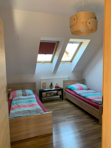 2 Betten in einem Schlafzimmer im Dachgeschoss mit Oberlichtern in der Unterkunft Apartamenty ANNA in Brenna