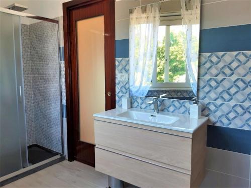 a bathroom with a sink and a mirror and a shower at casa dei Mori in Milazzo